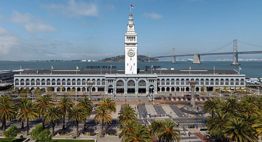 The Ferry Building is a terminal for ferries on the San Francisco Bay and an upscale shopping center located on The Embarcadero in San Francisco, California . The Bay Bridge can be seen in the backgro